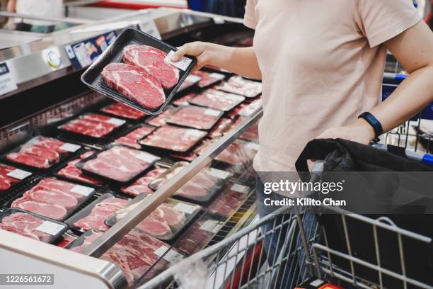 woman shopping at meat section - viande rouge photos et images de collection