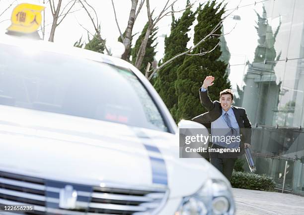 businessman stopping a taxi - chasing taxi stock pictures, royalty-free photos & images
