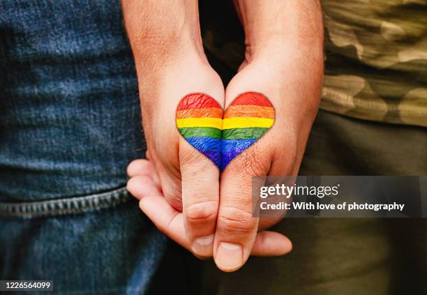 rainbow heart drawing on hands, lgbtq love symbol, gay couple hand in hand, lovers - gay love ストックフォトと画像