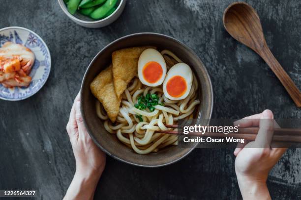 woman eating a bowl of traditional vegetarian japanese udon noodles - japanese food 個照片及圖片檔