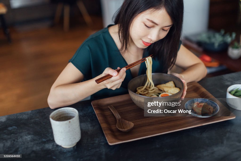 Young Woman Eating A Bowl Of Traditional Vegetarian Japanese Udon Noodles