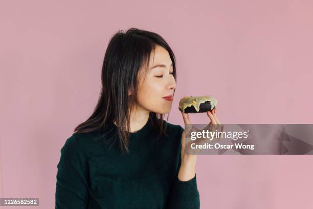 indulging in desserts - eating donuts foto e immagini stock