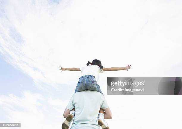 father carrying daughter on his shoulders - girl bums 個照片及圖片檔