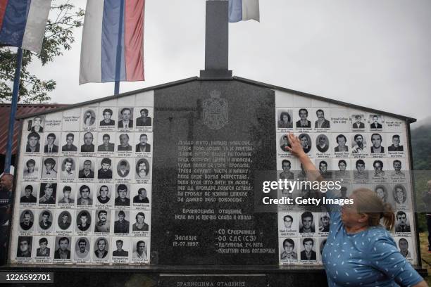 Bosnian Serb woman, whose sister was killed exactly 28 years ago, tries to touch her picture during the ceremony commemorating Bosnian Serbs killed...