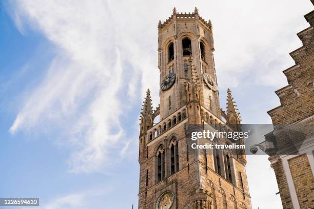 Architecture of house and retail shop with background of Brugge Belfry tower and Grote markt square in Bruges, Belgium on sunset Brugge, Belgium