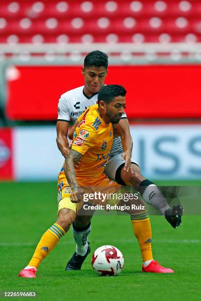 Jesús Angulo of Atlas fights for the ball with Javier Aquino of Tigres during the match between Atlas and Tigres UANL as part of the friendship...