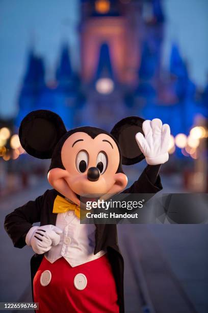 In this handout photo provided by Walt Disney World Resort, Mickey Mouse pauses on Main Street, U.S.A. Just before sunrise at Walt Disney World...