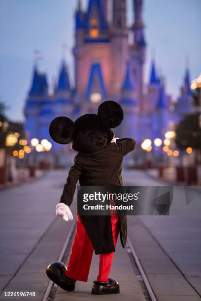 In this handout photo provided by Walt Disney World Resort, Mickey Mouse walks down Main Street, U.S.A. Just before sunrise at Walt Disney World...