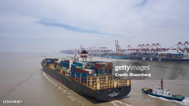The Kota Cepat vessel loaded with shipping containers approaches the Yangshan Deepwater Port in this aerial photograph taken in Shanghai, China, on...