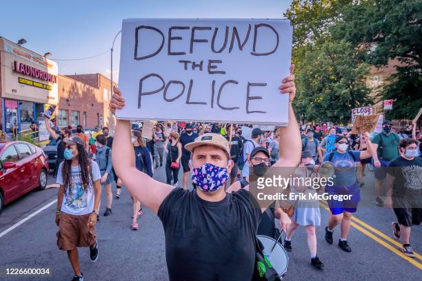 Counterprotester holding a Defund Police sign at the protest. Pro-NYPD marchers clashed with a big crowd of Black Lives Matter counterprotesters...