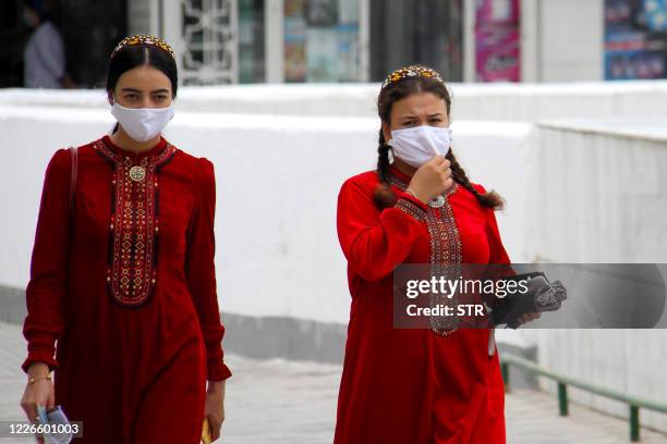 Turkmen women wearing face masks walk in Ashgabat on July 13, 2020. - Reclusive Turkmenistan on July 13 recommended that residents wear masks because...