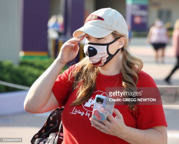 Guest wearing a protective mask arrives at the Magic Kingdom theme park at Walt Disney World on the first day of reopening, in Orlando, Florida, on...