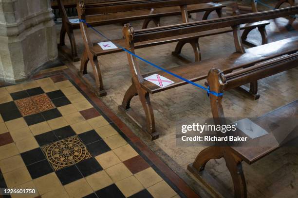 Church seating pews are marked with ticks and crosses marking where parishioners are allowed to sit according to Coronavirus pandemic lockdown...