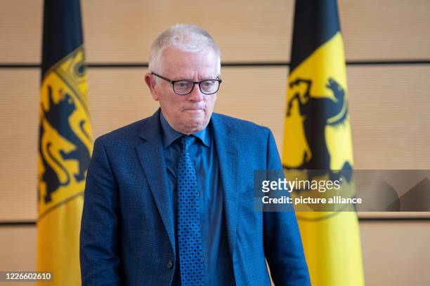 July 2020, Baden-Wuerttemberg, Stuttgart: Fritz Kuhn , Lord Mayor of Stuttgart, passes in front of two flags with the coat of arms of...