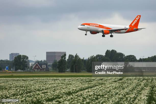 EasyJet Europe low cost airline Airbus A320 aircraft as seen on final approach on final flying, touch down, landing and breaking phase at Amsterdam...