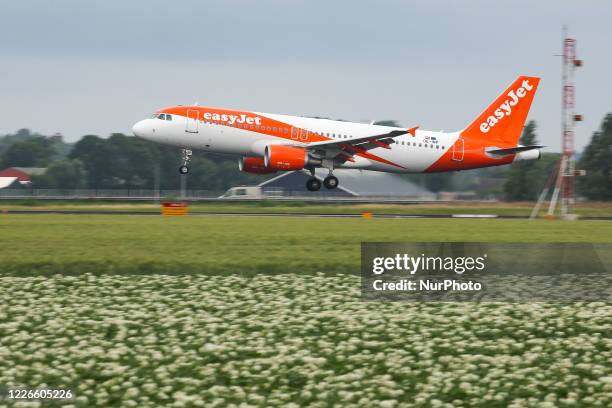 EasyJet Europe low cost airline Airbus A320 aircraft as seen on final approach on final flying, touch down, landing and breaking phase at Amsterdam...