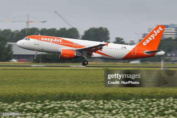 EasyJet Europe low cost airline Airbus A320 aircraft as seen on final approach on final flying, touch down, landing and breaking phase at Amsterdam...