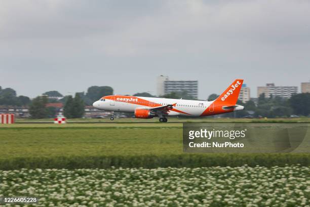 EasyJet Europe low cost airline Airbus A320 aircraft as seen on final approach on final flying, touch down, landing and breaking phase at Amsterdam...