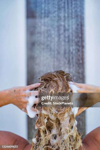 close-up jonge vrouw die haar met shampoo wast - haar wassen stockfoto's en -beelden