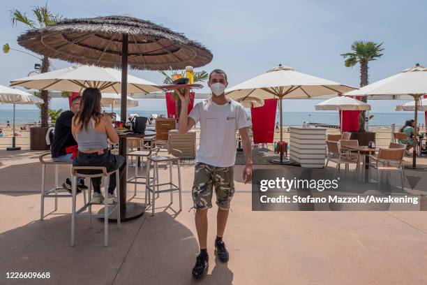 Tourists are sitting to drink and eat at the "Capannina Beach" in Jesolo, from today the beaches of Veneto have reopened. On May 23, 2020 in Venice,...