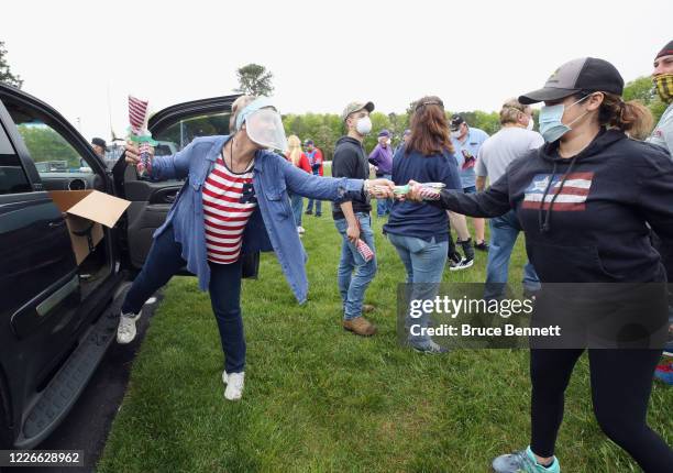 Holly Meyer hands out flags to volunteers to place at the Calverton National Cemetery on May 23, 2020 in Wading River, New York. The U.S. Department...