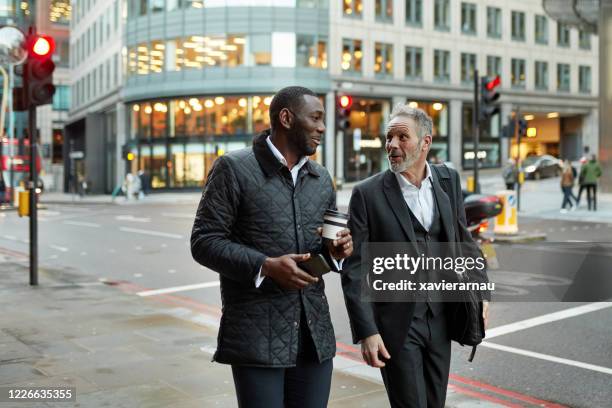 london business colleagues walking and talking after work - waxed jacket stock pictures, royalty-free photos & images