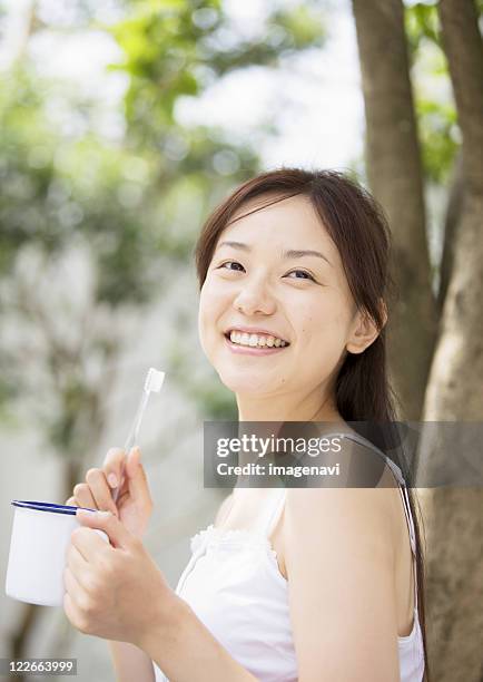 a woman holding brush - キャミソール ストックフォトと画像