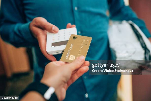 contactless payment using a credit card - debit cards credit cards accepted stock pictures, royalty-free photos & images