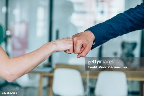 fist bump greeting! - fist bump stock pictures, royalty-free photos & images