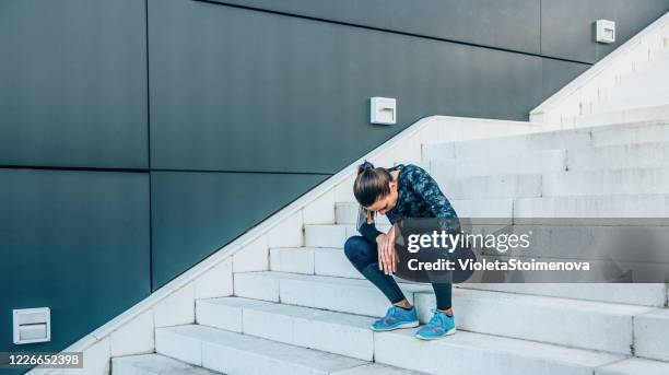 exhausted runner resting on the stairs after exercise. - exhausted runner stock pictures, royalty-free photos & images