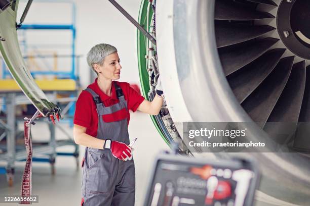 aircraft mechanic is working in an airplane hangar - aircraft maintenance stock pictures, royalty-free photos & images