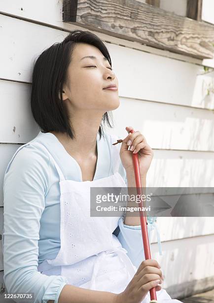 a woman having a break - holding broom stock pictures, royalty-free photos & images