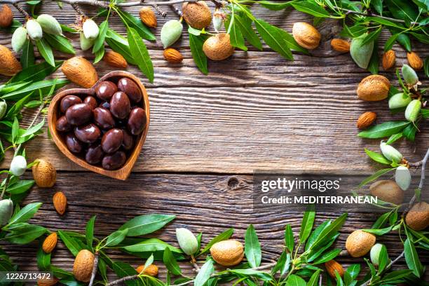 almendras de chocolate oscuro corazón forma tazón borde marco de copia espacio de copia - almond branch fotografías e imágenes de stock