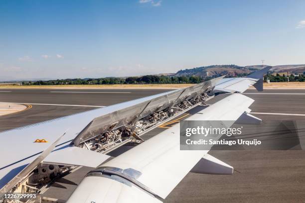 airplane wing with its flaps up while landing - klapwieken stockfoto's en -beelden