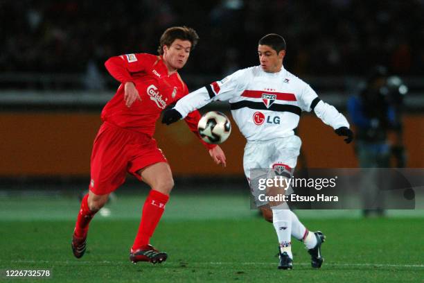 Cicinho of Sao Paulo and Xabi Alonso of Liverpool compete for the ball during the FIFA Club World Championship Toyota Cup final between Sao Paulo and...
