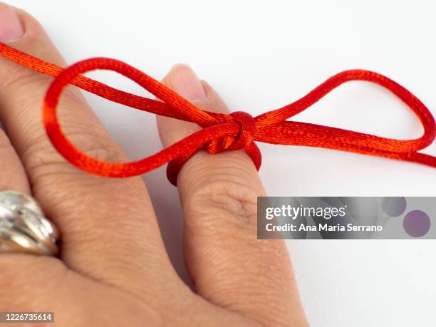 a red thread legend. a person's hand with a red thread tied on its little finger - ana maria parera bildbanksfoton och bilder