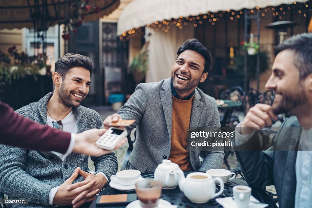 Businessman paying the bill in cafe with a credit card