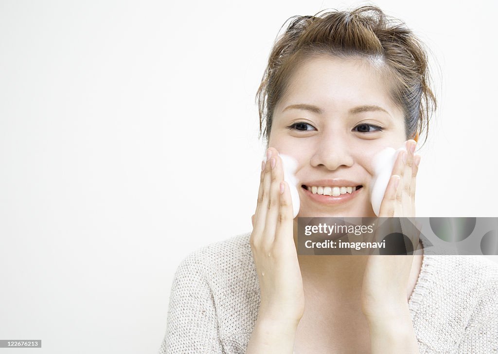 A young woman washing her face