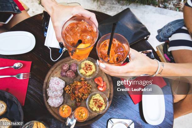 friends celebrating toasting cocktails together - friends toasting above table stock pictures, royalty-free photos & images