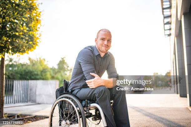 openluchtportret van ontspannen jonge zakenman in rolstoel - rolstoel stockfoto's en -beelden