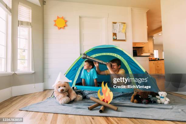 jungen erkunden mit teleskop in innenräumen - besuch zuhause sommerlich innenaufnahme stock-fotos und bilder