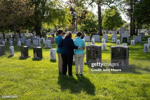 Traci Voelke and her sons AJ and Benjamin visit the grave of her husband U.S. Army Maj. Paul Voelke at the United States Military Academy cemetery on...