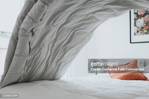 making the bed - bedclothes stockfoto's en -beelden