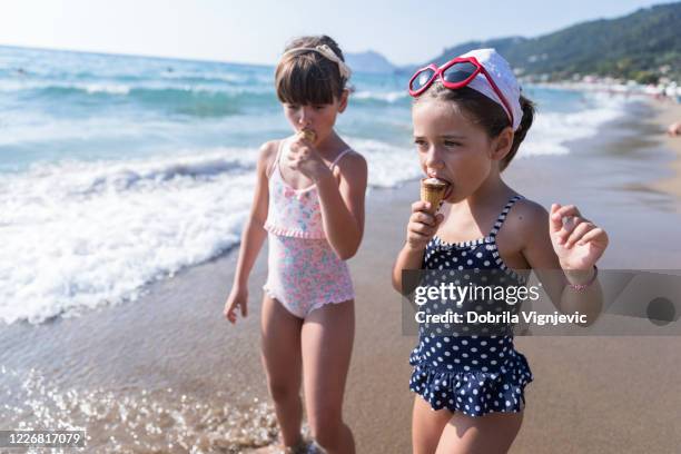 flicka som har glass när du går in i havet - pretty girls in swimsuits bildbanksfoton och bilder