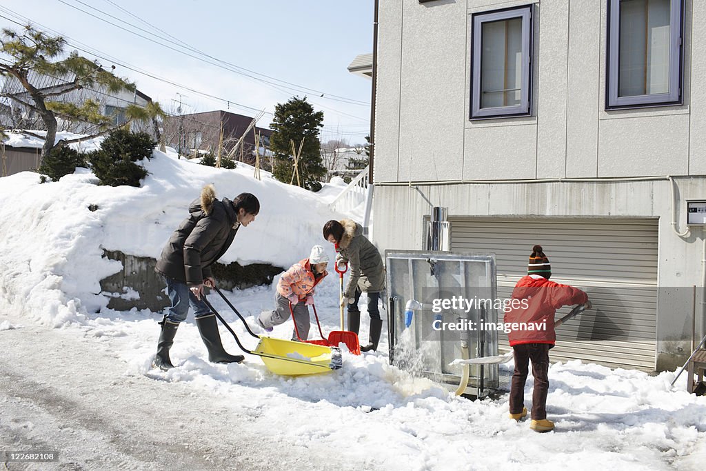 Family removing snow