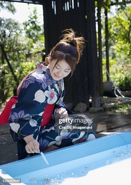woman scooping goldfish with kimono - woman smiling facing down stock pictures, royalty-free photos & images