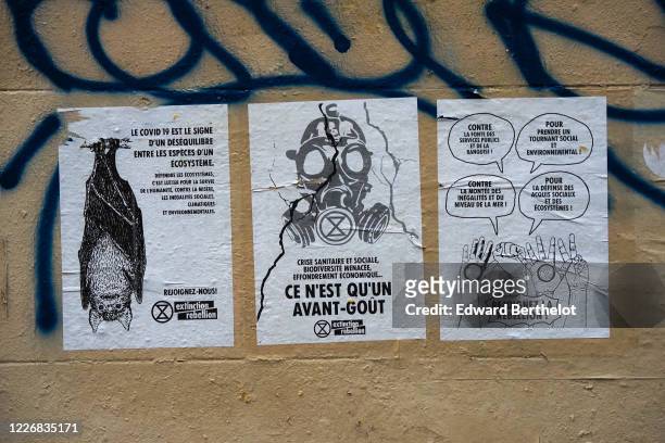 Protest posters showing pictures of a bat, a gaz mask, and the messages "Le covid 19 est le signe d'un desequilibre entre les especes d'un...