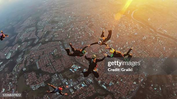 skydiving group at the sunset - aerial stunts flying stock pictures, royalty-free photos & images