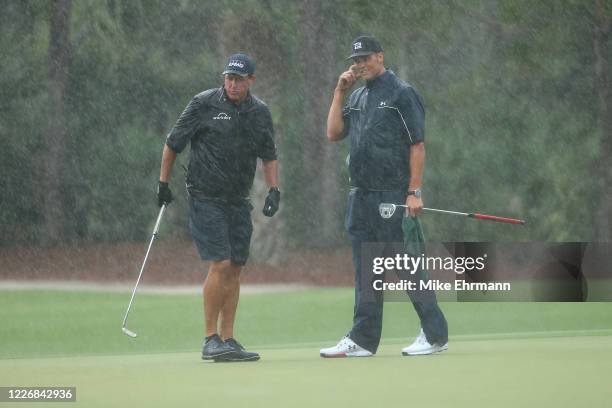 Phil Mickelson and NFL player Tom Brady of the Tampa Bay Buccaneers react on the 13th green during The Match: Champions For Charity at Medalist Golf...