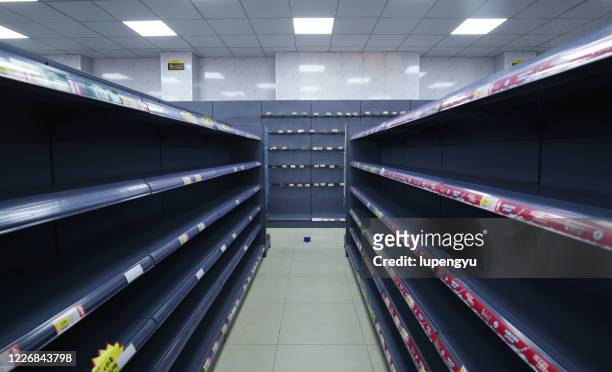 coronavirus, covid-19 pandemic, empty supermarket shelves from panic buying - travée photos et images de collection